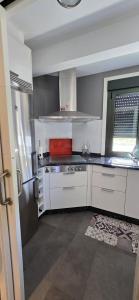a kitchen with white cabinets and a stainless steel refrigerator at Casa Arena 2 in Nigrán