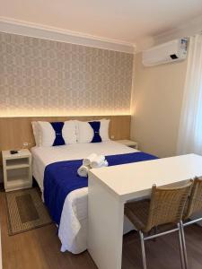 a hotel room with a bed and a table and chairs at CAPÃO Da CANOA MAR HOTEL in Capão da Canoa