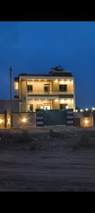 a building with lights in front of it at night at Shree Karan Palace Family Guest House in Juliāsar