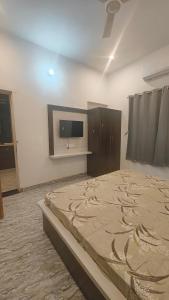 a bedroom with a large bed and a flat screen tv at Shree Karan Palace Family Guest House in Juliāsar