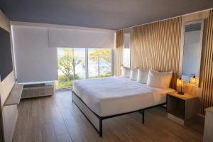 a bedroom with a large bed and a large window at Tropical Palms Hotel in Clearwater