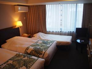 ein Hotelzimmer mit 2 Betten und einem Fenster in der Unterkunft Breezbay Hotel Resort and Spa in Yokohama