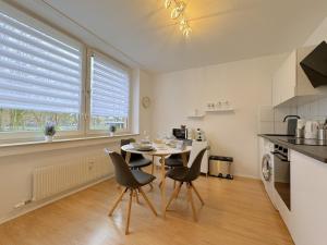 a kitchen with a table and chairs in a kitchen at Dein Apartment mit Queensize Bett im Erdgeschoss in Neukirchen-Vluyn