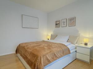 a white bedroom with a bed and two lamps at Dein Apartment mit Queensize Bett im Erdgeschoss in Neukirchen-Vluyn