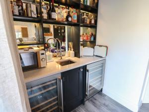 a kitchen with a counter with a sink and a microwave at The Summerhouse in Keighley +27 photos