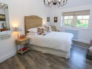 a bedroom with a bed and a lamp and a table at The Summerhouse in Keighley
