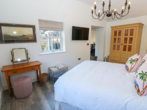 a bedroom with a bed and a table and a mirror at The Summerhouse in Keighley