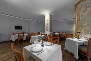 a dining room with tables and chairs with white tablecloths at Porto Azul Hotel Bodrum in Bodrum City