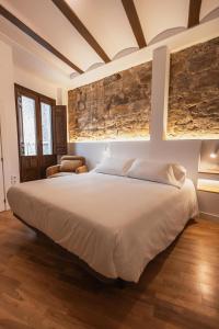 a bedroom with a large white bed and a chair at Boutique Casa de los Pedraza in Baeza