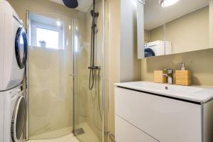 a white bathroom with a shower and a sink at Spacious Five Bedroom Central Oslo in Oslo