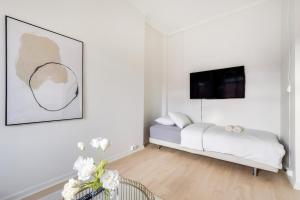 a white bedroom with a bed and a tv at Spacious Five Bedroom Central Oslo in Oslo +9 photos