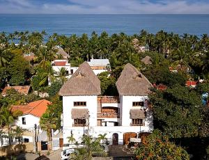 an aerial view of a white house with trees and the ocean at Amari Sayulita Boutique Hotel in Sayulita