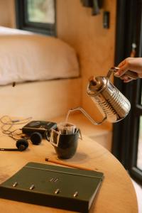 a person is pouring coffee into a cup on a table at Cabana Fora in São Francisco de Paula