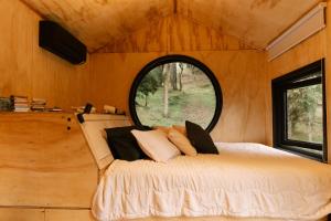 a bed in a small room with a window at Cabana Fora in São Francisco de Paula