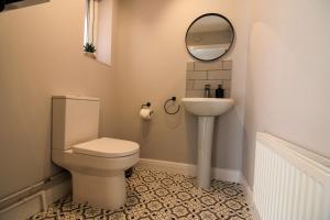 a bathroom with a toilet and a sink and a mirror at Restful Riverside Residence in Morton +14 photos