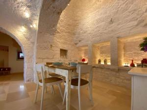 a dining room with a wooden table and chairs at Trullo al borgo in Cisternino