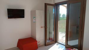 a room with a television and a sliding glass door at Il giardino dei tramonti in Nardò
