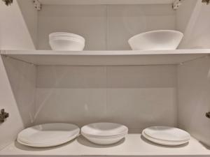 two white toilets in a white bathroom with shelves at Central Platinum Apartments 14 in Rybnik +18 photos