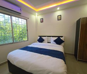 a bedroom with a large bed with blue and white pillows at Laxmi raj awasiye hotel in Bettiah