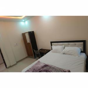 a bedroom with a bed with white sheets and pillows at Laxmi raj awasiye hotel in Bettiah