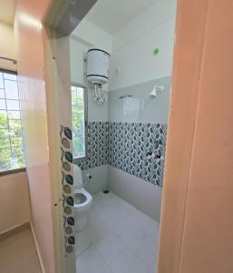 a bathroom with a toilet and a window at Laxmi raj awasiye hotel in Bettiah