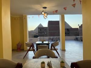 a room with a table and chairs and a large window at Saloumy pyramids hotel in Nazlat as Sammān