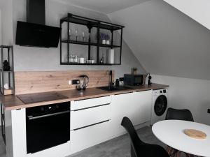 a kitchen with a counter and a sink and a table at Vila SoHo in Vysoké Mýto