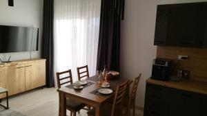 a dining room with a table and chairs and a television at Wind Rose Montenegro in Igalo