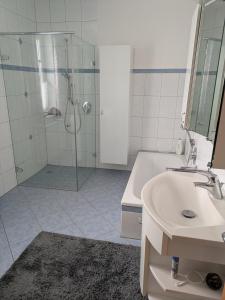 a bathroom with a shower and a sink and a tub at Ferienwohnung zum Utzen in Berching +10 photos