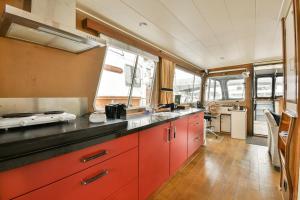 a kitchen with red cabinets in a bus at Authentic houseboat Amalia in Amsterdam