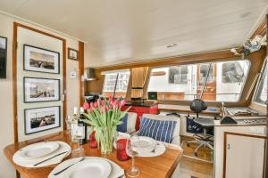 a dining room with a table with flowers on it at Authentic houseboat Amalia in Amsterdam