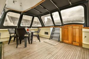 a dining room on a boat with a table and chairs at Authentic houseboat Amalia in Amsterdam