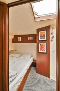 a small bedroom with a bed in a boat at Authentic houseboat Amalia in Amsterdam +17 photos