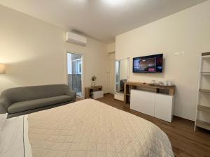 a bedroom with a bed and a couch and a television at Monte Boutique ROOMS in Montepulciano