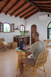 a man sitting in a chair using a laptop at Amari Sayulita Boutique Hotel in Sayulita