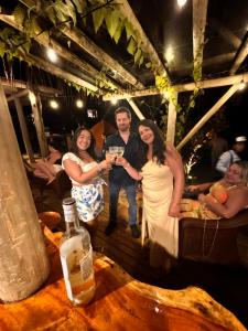 a man and two women are holding a glass at FLORA Praia do Sono in Paraty