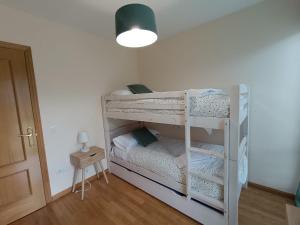two bunk beds in a room with a lamp at Inmocyma Los Almendros in Castejón de Sos