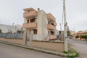 a building on the side of a street with a fence at ilvilLINO in Taranto