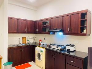 a kitchen with wooden cabinets and a washing machine at Liyasha Villa - AEONSKY in Negombo