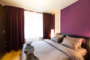 モスクワにあるLux Apartments Taganskayaのベッドルーム1室(紫の壁のベッド1台、窓付)