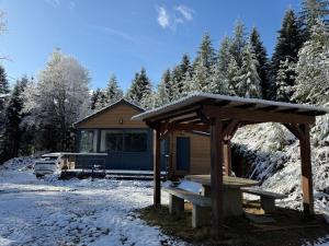 a wooden cabin with a bench in the snow at Chalet dans la nature in Palisse