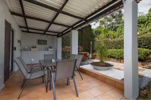 a patio with a table and chairs and a kitchen at The Old Stone House in Kloof