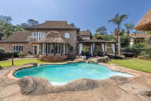 a swimming pool in front of a house at The Old Stone House in Kloof
