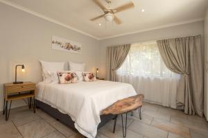 a bedroom with a large white bed with a window at The Old Stone House in Kloof +14 photos