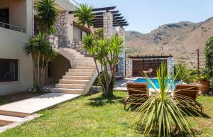 a house with stairs next to a swimming pool at Villa Majestic Heated Pool Sauna & Endless Sea Views in Megála Khoráfia