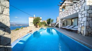 a swimming pool in a villa with a view of the water at Villa Majestic Heated Pool Sauna & Endless Sea Views in Megála Khoráfia