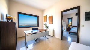 a room with a desk and a window and a bed at Villa Majestic Heated Pool Sauna & Endless Sea Views in Megála Khoráfia