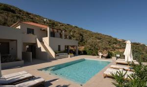 a villa with a swimming pool in front of a mountain at Oleander Evia in Agioi Apostoli