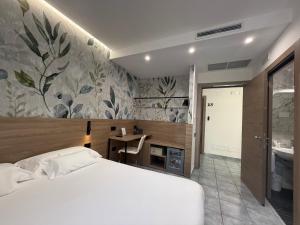 una camera da letto con letto, scrivania e bagno di Hotel Maiuri Pompei a Pompei Altre 43 foto