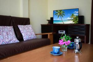 a living room with a couch and a table with flowers at Windy Villa by Utalay Koh Chang in Ban Khlong Son